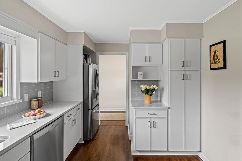 A kitchen with white cabinets
Description automatically generated